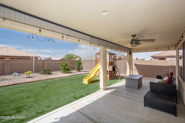 view of patio / terrace featuring a fenced backyard, ceiling fan, and a playground