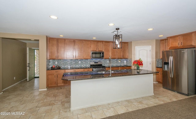kitchen featuring brown cabinetry, a sink, stainless steel appliances, and backsplash