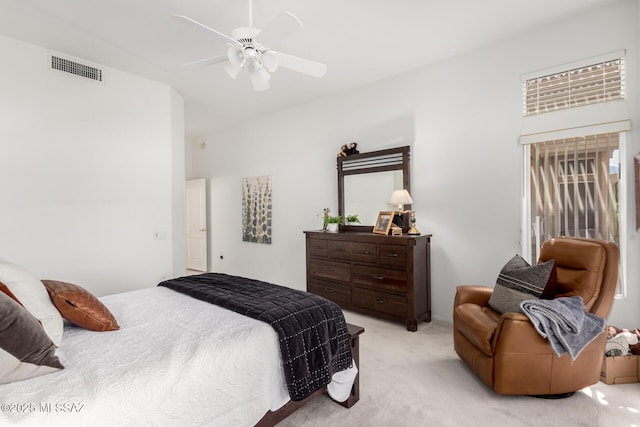bedroom featuring visible vents, a ceiling fan, and light carpet