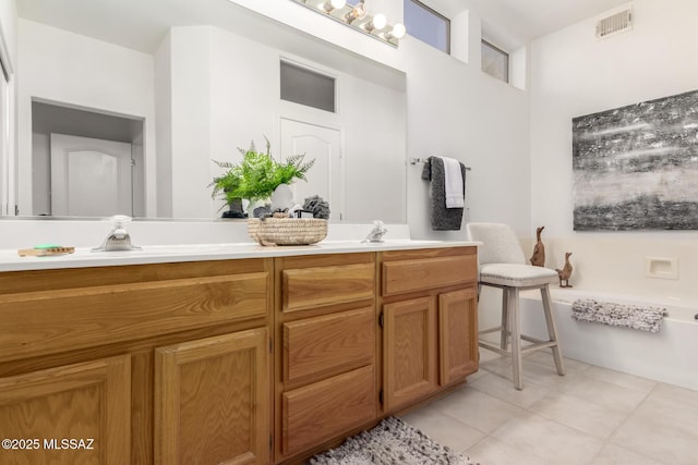 full bathroom featuring tile patterned floors, a bathing tub, a sink, visible vents, and double vanity