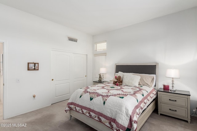 bedroom featuring a closet, light colored carpet, and visible vents