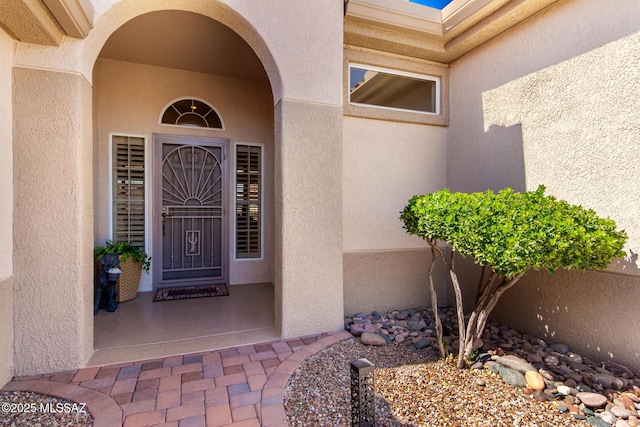 doorway to property featuring stucco siding