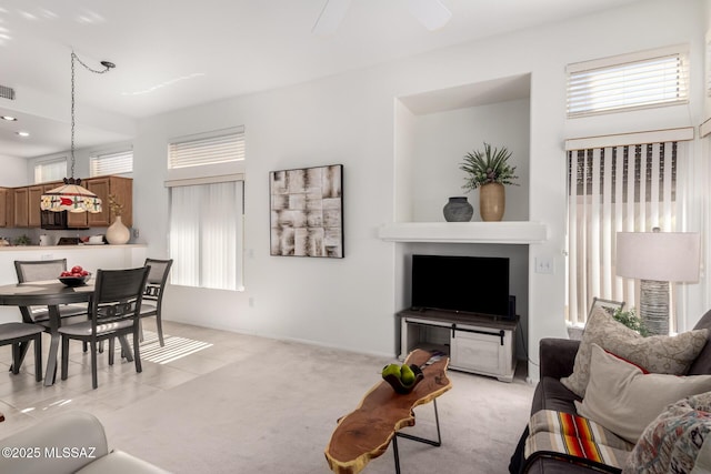 living area featuring a ceiling fan and light carpet