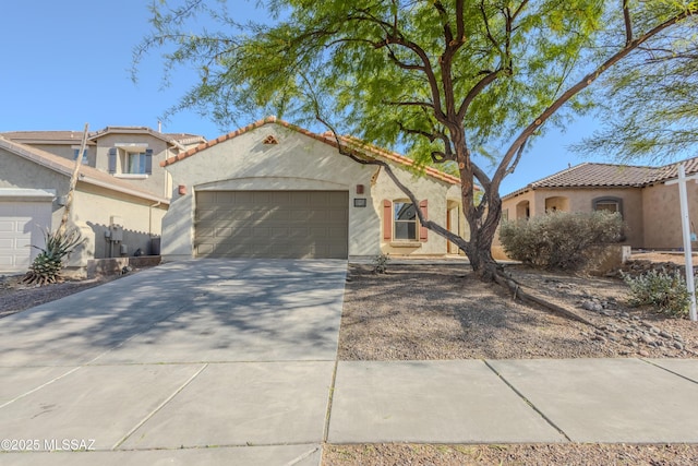 mediterranean / spanish home featuring stucco siding, a tiled roof, driveway, and an attached garage