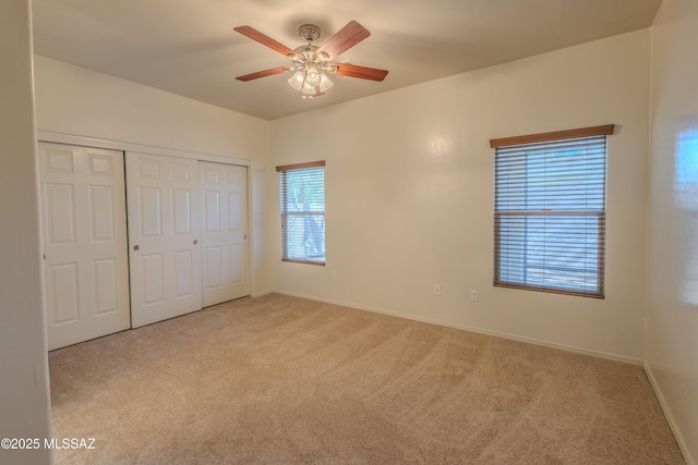 unfurnished bedroom featuring baseboards, a ceiling fan, a closet, and carpet