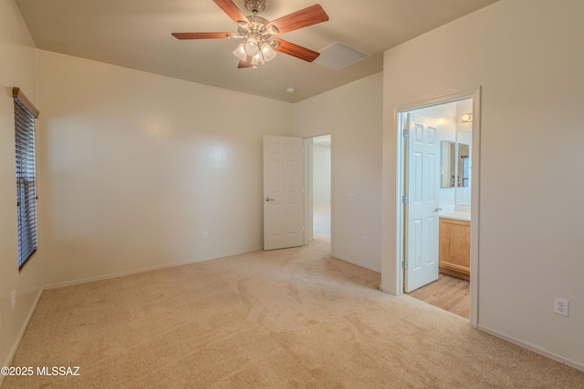 unfurnished bedroom with baseboards, light carpet, and ensuite bathroom