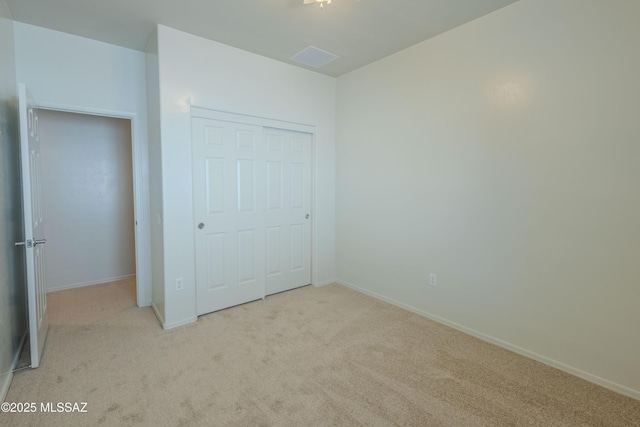 unfurnished bedroom with baseboards, carpet floors, and a closet