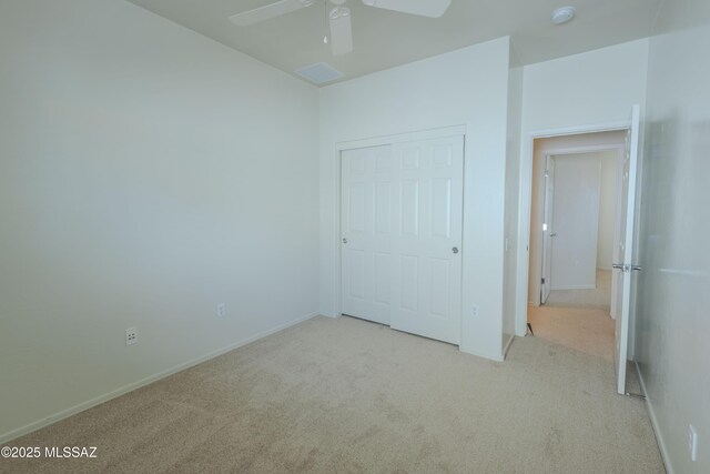 unfurnished bedroom featuring a closet, ceiling fan, carpet, and baseboards