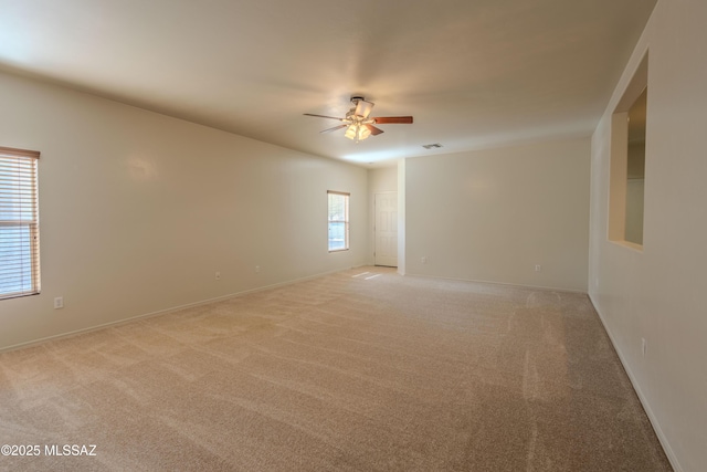 unfurnished room with ceiling fan, baseboards, light carpet, and visible vents