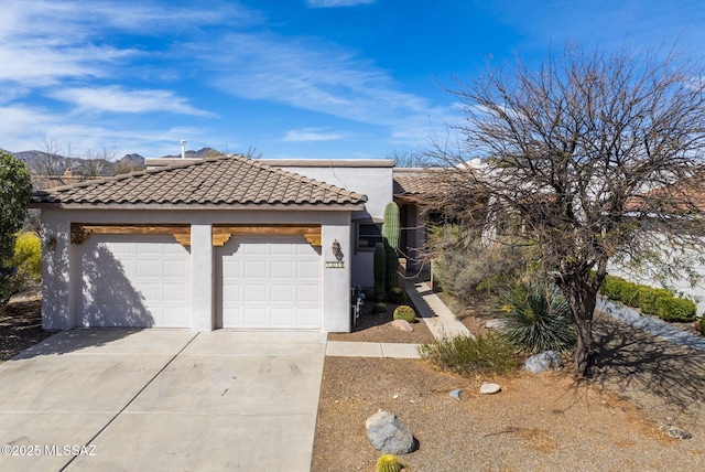 view of front of property with stucco siding, a garage, and a tile roof