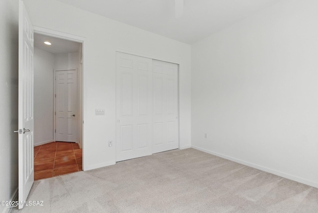 unfurnished bedroom featuring a closet, baseboards, and carpet