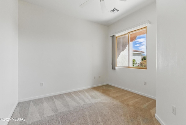 carpeted empty room featuring visible vents, baseboards, and ceiling fan