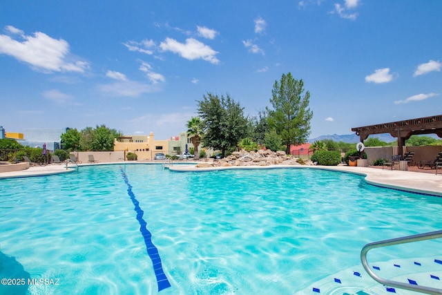 pool with a patio and fence