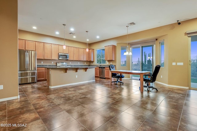 kitchen with a kitchen island, a kitchen breakfast bar, appliances with stainless steel finishes, baseboards, and visible vents