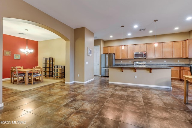 kitchen with visible vents, a chandelier, a kitchen bar, stainless steel appliances, and arched walkways