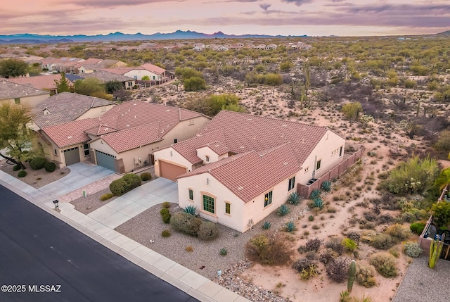 aerial view at dusk featuring a residential view and a mountain view