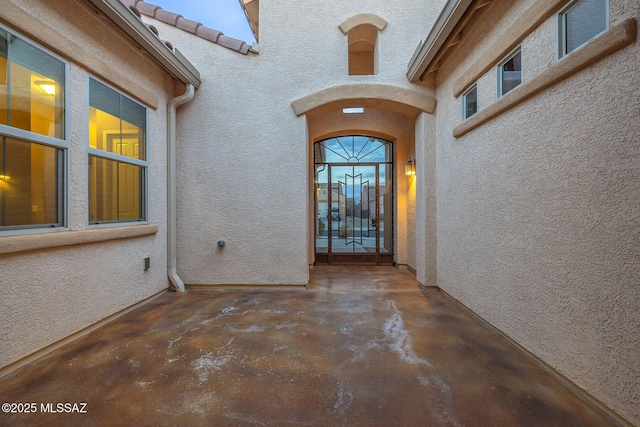 doorway to property featuring stucco siding and a tiled roof