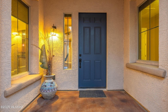 doorway to property featuring stucco siding