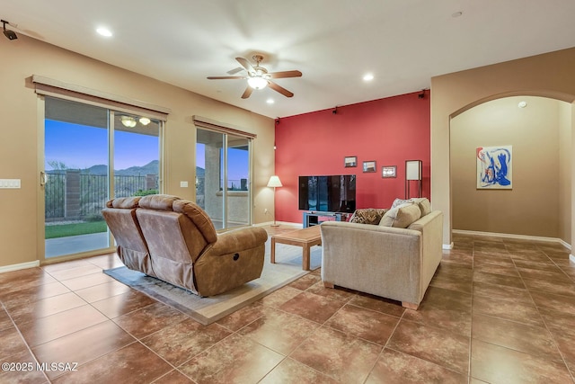 living room with baseboards, arched walkways, recessed lighting, and a ceiling fan