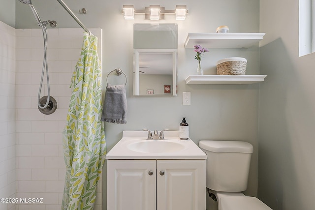 full bath featuring toilet, tiled shower, and vanity