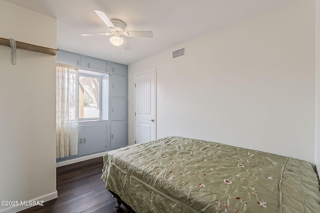bedroom with dark wood-style flooring, visible vents, and a ceiling fan