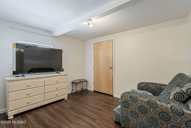 sitting room featuring beam ceiling, dark wood-style flooring, and baseboards