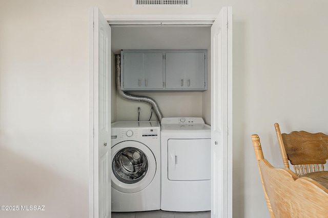 laundry room with visible vents, cabinet space, and washer and clothes dryer