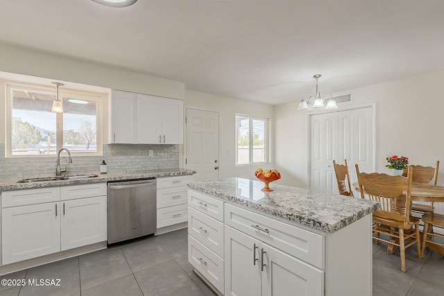 kitchen with an inviting chandelier, stainless steel dishwasher, light tile patterned floors, backsplash, and a sink