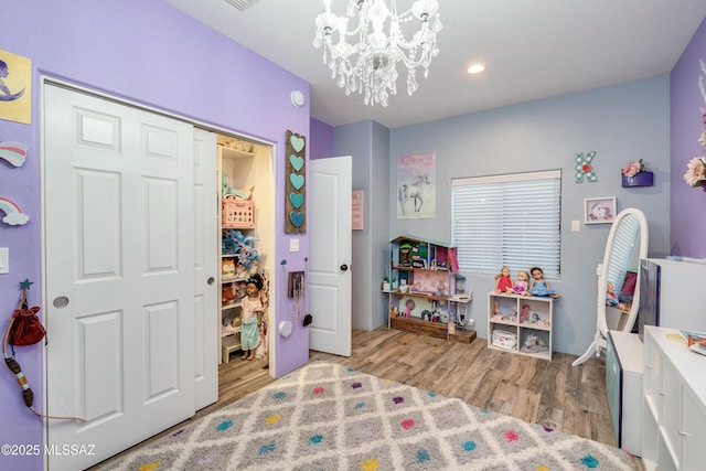 bedroom with recessed lighting, a notable chandelier, and wood finished floors