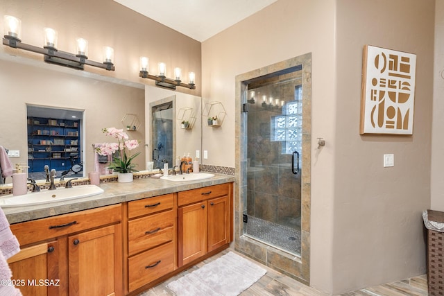 full bath with a sink, double vanity, and a shower stall