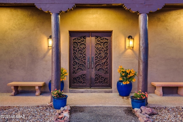 entrance to property featuring stucco siding