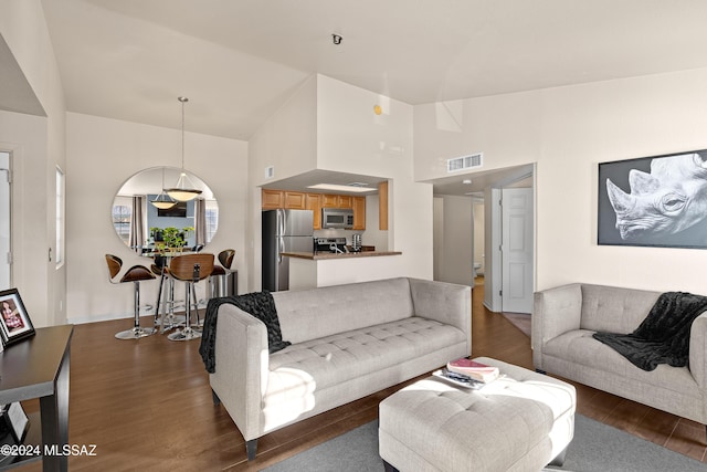 living room featuring visible vents, high vaulted ceiling, and wood finished floors