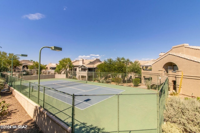 view of sport court with a residential view and fence