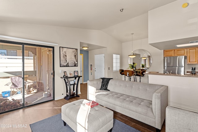 living area with wood finished floors, baseboards, and vaulted ceiling