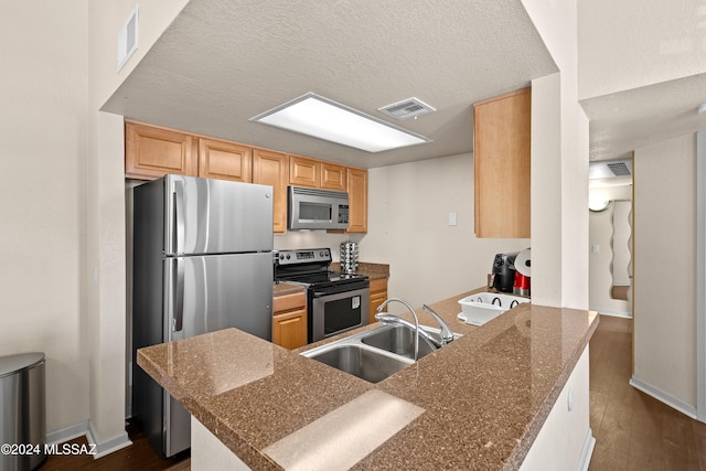 kitchen with a sink, visible vents, dark wood-type flooring, and appliances with stainless steel finishes