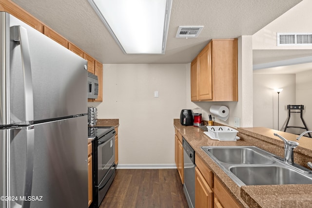 kitchen with visible vents, dark wood-style flooring, stainless steel appliances, and a sink