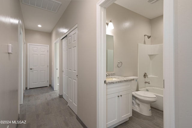 bathroom featuring vanity, toilet, wood finished floors, shower / bathing tub combination, and visible vents