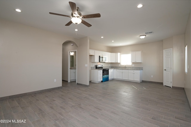 kitchen with electric range, a ceiling fan, stainless steel microwave, baseboards, and visible vents