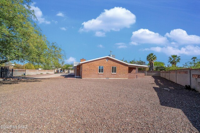 2350 E Juanita St, Tucson, AZ 85719 - rear view of property featuring brick siding, fence, a chimney, and a gate