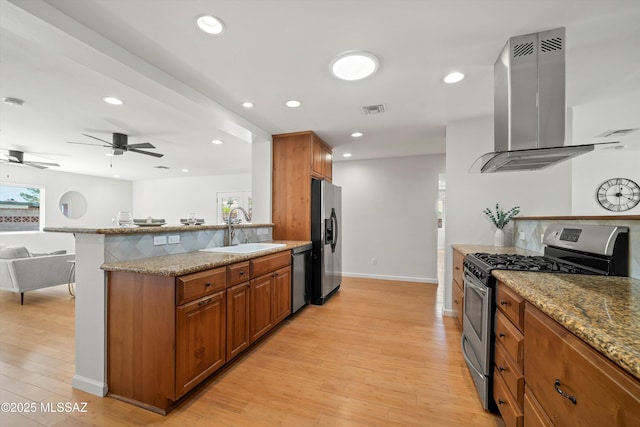 2350 E Juanita St, Tucson, AZ 85719 - kitchen with stainless steel appliances, island exhaust hood, a sink, brown cabinetry, and light wood-style floors