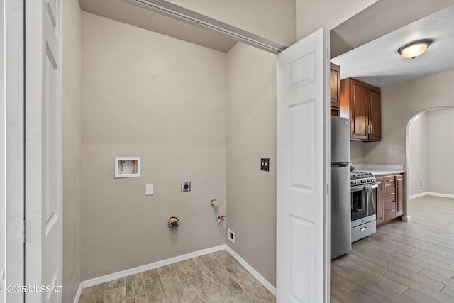 clothes washing area featuring electric dryer hookup, wood finish floors, gas dryer hookup, and washer hookup