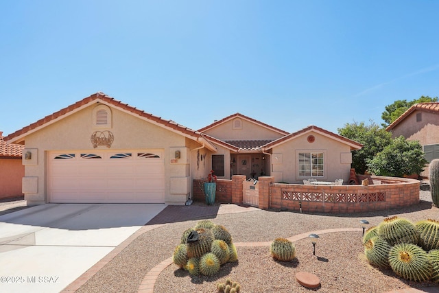 mediterranean / spanish-style home with a tile roof, a garage, driveway, and stucco siding