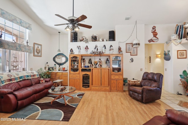 living room featuring visible vents, light wood-style floors, and a ceiling fan