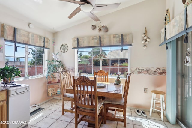 dining area with light tile patterned flooring, lofted ceiling, ceiling fan, and baseboards
