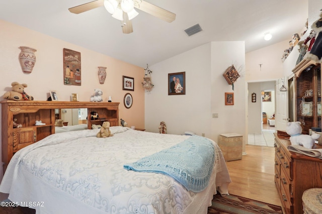 bedroom with visible vents, light wood-style floors, lofted ceiling, and a ceiling fan