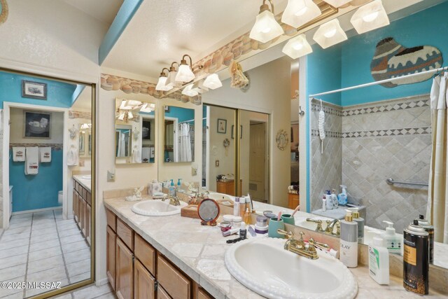 full bath with double vanity, curtained shower, tile patterned flooring, and a sink