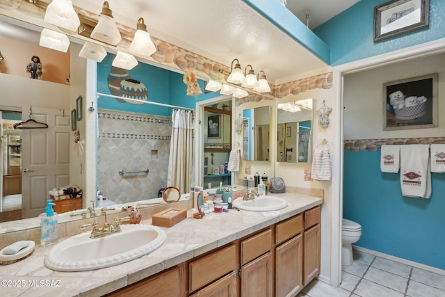 bathroom featuring a shower with curtain, toilet, a sink, and tile patterned flooring