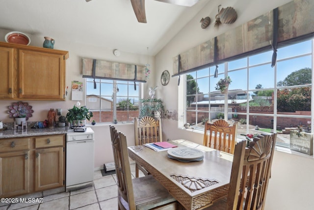dining space featuring light tile patterned flooring, ceiling fan, and vaulted ceiling