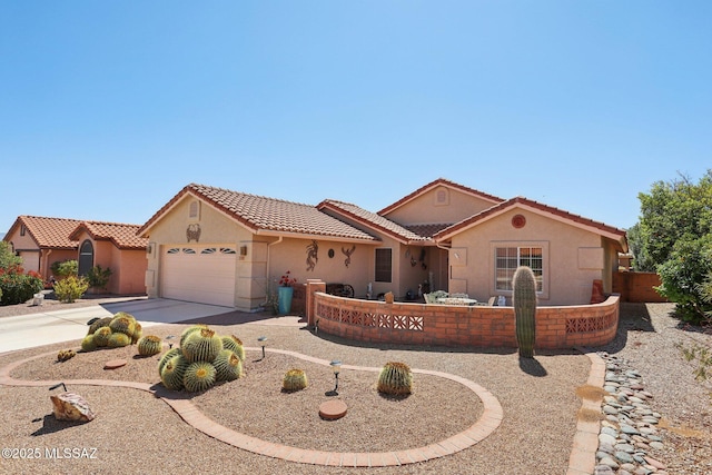 mediterranean / spanish home featuring a tile roof, stucco siding, a garage, and concrete driveway