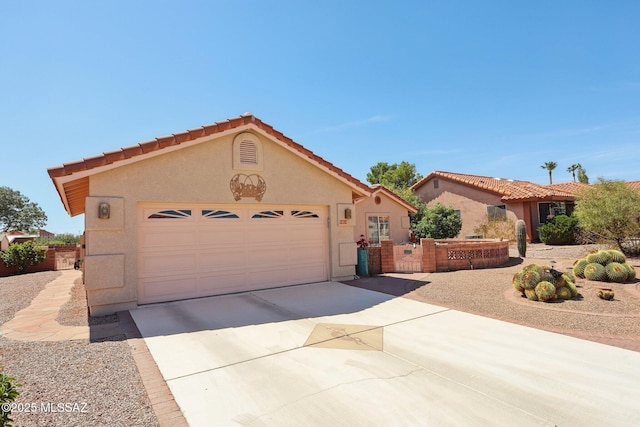 mediterranean / spanish home with a tile roof, a garage, concrete driveway, and stucco siding